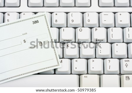 A blank cheque sitting on a computer keyboard, making money online
