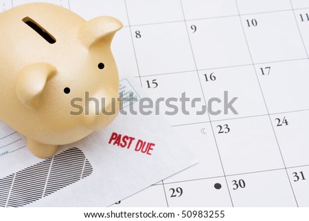 A past due bill sitting with a piggy bank on a calendar, Behind on your bills