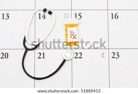 A pill bottle and a stethoscope on a calendar background, doctor appointment