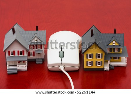 A model house sitting with a computer mouse on a red background, online real estate