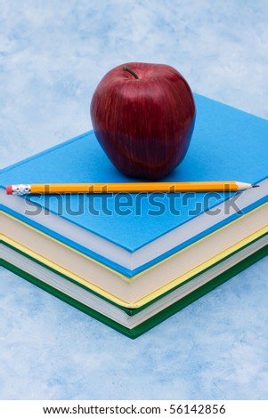 A stack of book with an apple and a pencil on a blue background, education