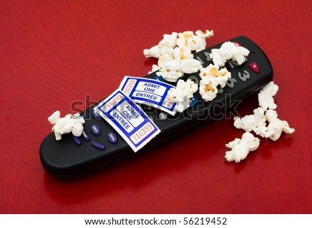 Popcorn and tickets with a remote control on a wood background, Home entertainment