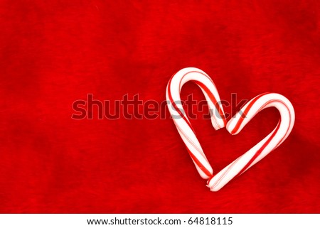 Two candy canes making a heart on a red textured background, Candy cane heart