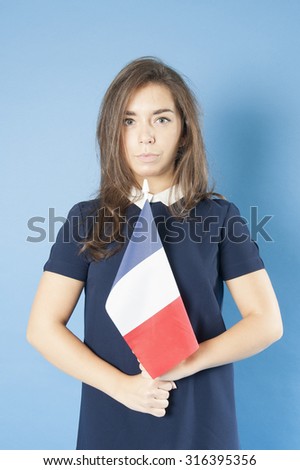 Young girl holding the French flag triumphantly.
