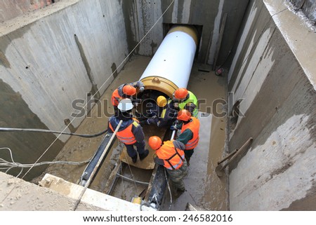 Workers are laying pipes at a construction site