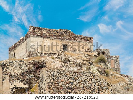The Venetian Castle of Akrotiri village against blue summer sky, Santorini island, Greece