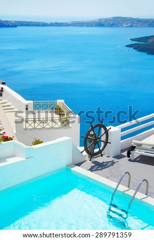 Beautiful sea view at Santorini island, Greece. Swimming pool in luxury hotel and big liners at sea.