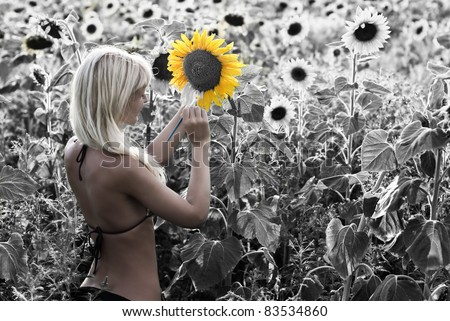 The blond girl painting the sunflower field in the bright colors - the concept of transformation of life - all in your hands