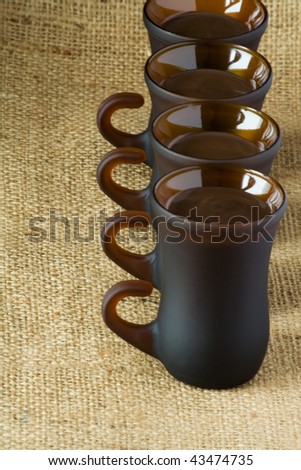 four glasses of liquor for on the background burlap