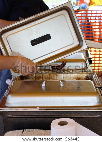 A roaster filled with brats is served at a public event