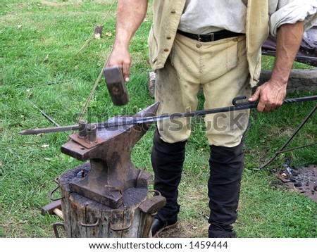 Blacksmith straightens out a piece of wrought iron for a customer.