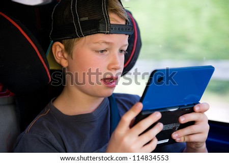 boy is playing electronic-game in the car