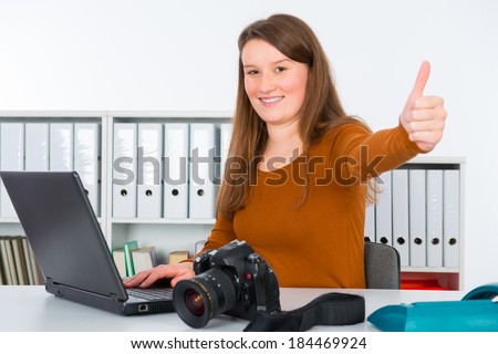 young reporter in editorial office with thumb up
