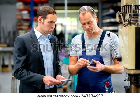in the factory- young boss and worker in conversation