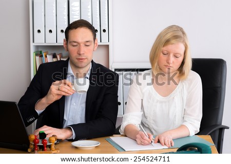 young man and woman working together in the office