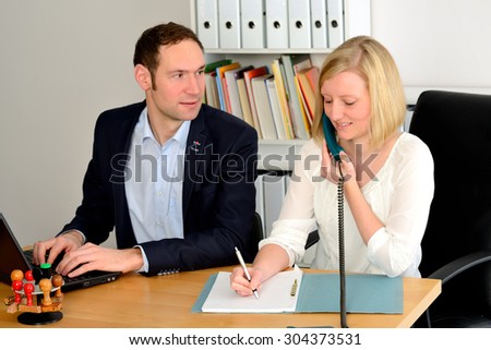 young man and woman working together in the office