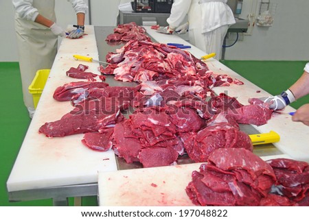 Butcher cutting a fresh beef meat
