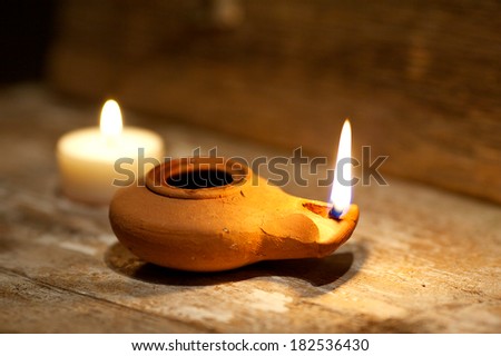 Ancient Middle Eastern oil lamp made in clay on wood table