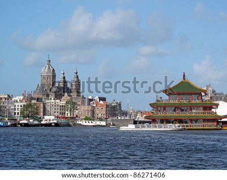Amsterdam skyline with floating Chinese restaurant. Urban landscape in Netherlands.
