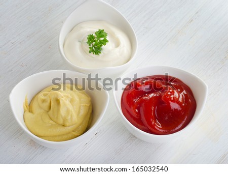 Mustard, ketchup and mayonnaise   on wooden table .Selective focus