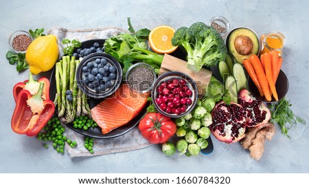 Healthy food selection on gray background. Detox and clean diet concept. Foods high in vitamins, minerals and antioxidants. Anti age foods. Top view