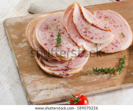Slices of mortadella on wooden platter. Selective focus