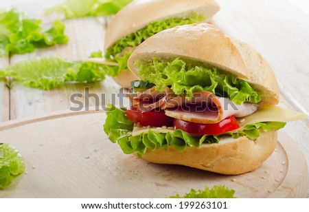 Fresh sandwich  on a wooden cutting board. Selective focus