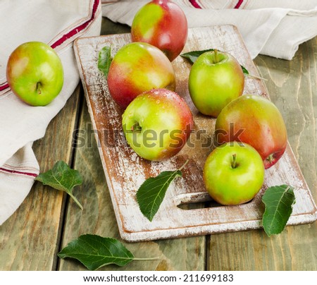 Apples with water drops on a wooden table.