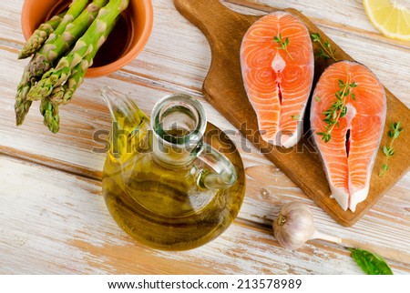 Healthy food  ingredients - salmon, vegetables and olive oil on a wooden table