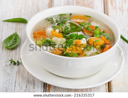Soup  with chicken and  vegetables on a wooden table . Selective focus