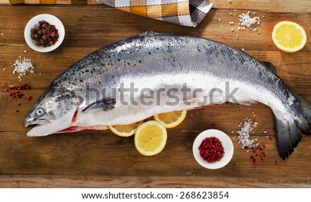 Atlantic Salmon  with lemon on a wooden board. Top view