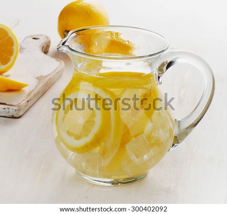 Water with lemon in a glass jug. Selective focus