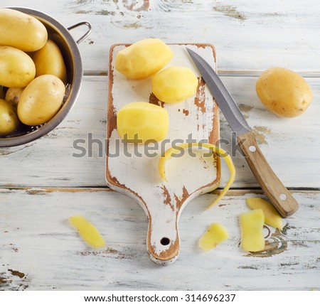 Raw potatoes on  white wooden background. Selective focus