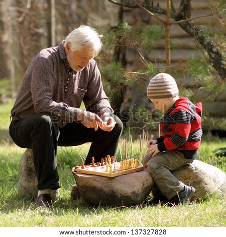 Grandfather and grandson playing chess. Grandfather and grandchild
