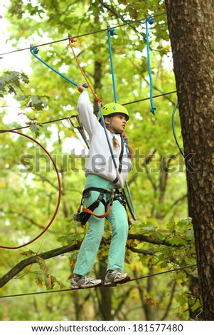 Child in the outfit climber climbs trees
