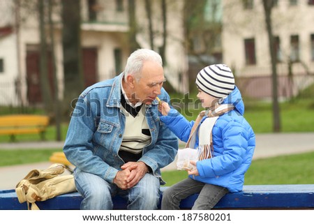 Grandfather and grandson eating fries and indulge
