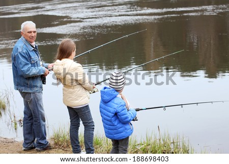 Grandfather and grandchildren are fishing. Grandfather and grandchild