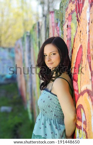 portrait of a happy beautiful girl  on the background wall graffiti. hipster photo