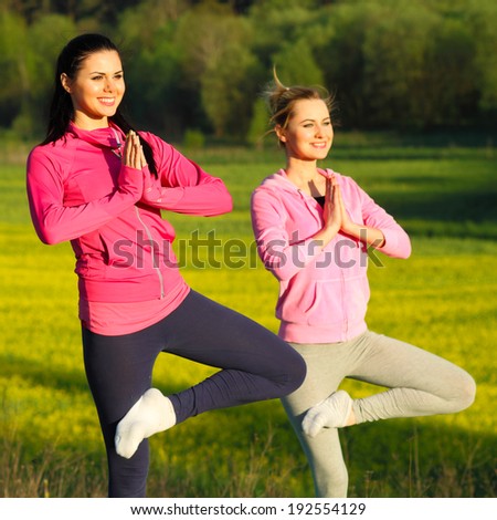 yoga Girls on the background field of yellow flowers. yoga instructor shows poses