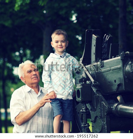Grandfather shows for his grandson old military artillery gun
