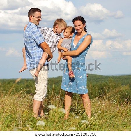 Family of four standing on a mountain on the background of clouds. Portrait of a happy family.