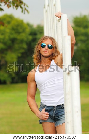 sexy caucasian fit man in sunglasses posing Strong and confident man posing outdoor