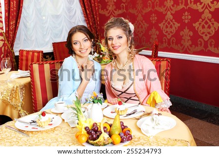 Girls in vintage dresses in the restaurant.  Retro Women Portrait. Romantic Beauty.Vintage Styled. Communication between two girls in the restaurant.