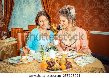 Girls in vintage dresses in the restaurant.  Retro Women Portrait. Romantic Beauty.Vintage Styled. Communication between two girls in the restaurant.