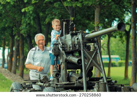 Grandfather shows for his grandson old military artillery gun