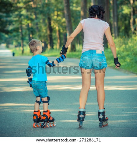 mother and son learn to roller skate. Mom with child having fun on roller skates