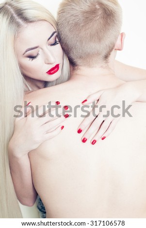 blonde and a man passionate embrace. Beautiful girl in the image of albino with red lips. Art beauty face. art photography with red lips and nails. art Photography