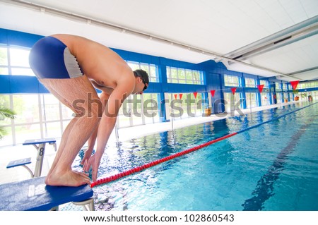 Professional Swimmer getting ready to jump in the swimming pool for practice.