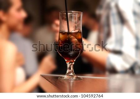 Alcoholic cocktail on bar with happy people background