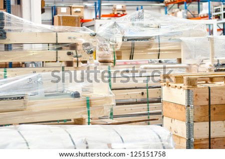 Industrial equipment stored in modern warehouse, on wooden pallets